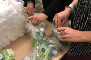 Photo of multiple hands building a Clean the World Hygiene Kit